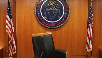 The seal of the Federal Communications Commission hangs behind commissioner Tom Wheeler's chair inside the hearing room at the FCC headquarters in Washington, D.C.