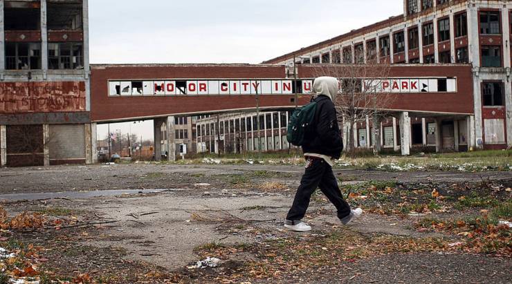 A person in Detroit walks past the remains of the Packard Motor Car Co., which ceased production in the late 1950s.