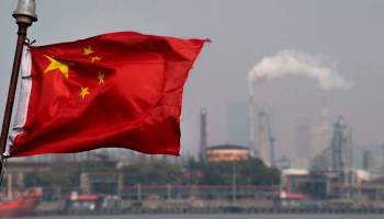 This picture taken on March 22, 2018 shows a Chinese flag fluttering in front of the Shanghai Gaoqiao Company Refinery in Shanghai.