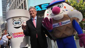 Nigel Travis, president and CEO of Dunkin' Brands, the parent company of Dunkin' Donuts and Baskin-Robbins, celebrates the initial public offering with some friends outside the NASDAQ MarketSite on July 27, 2011, in New York City.