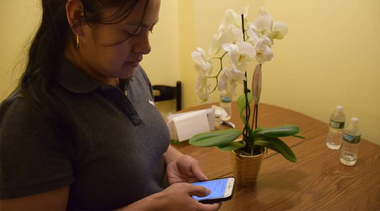 Olivia Mejia, a house cleaner in Brooklyn, logs into the Alia platform on her phone. She has taken out life insurance and accident insurance through the platform.