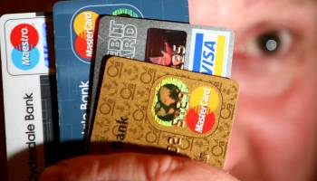 A man holds up some credit and debit cards
