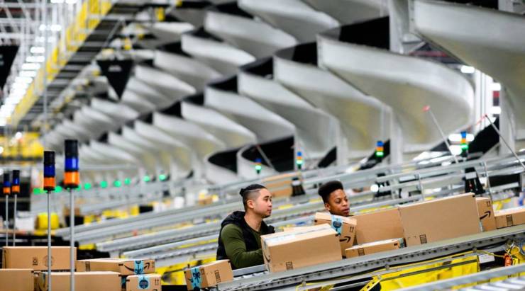 Men work at a distribution station in the 855,000-square-foot Amazon fulfillment center in Staten Island, New York, in February.