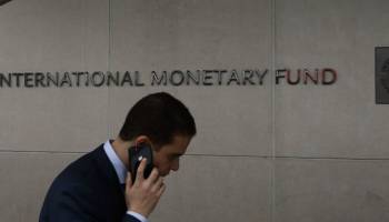 A man walks past the International Monetary Fund (IMF) building.