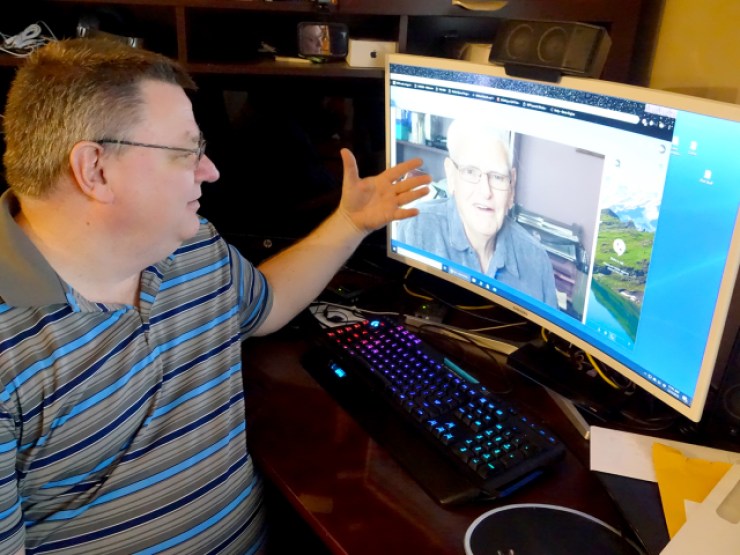 Chad Schreiber, who lives in a St. Louis, Missouri suburb, gestures toward a photo of his father, Art, on his computer.
