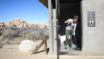 A volunteer cleans a restroom at Joshua Tree National Park on January 4, 2019 in California.