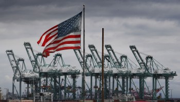 The U.S. flag flies over shipping cranes and containers in Long Beach, California, in March.