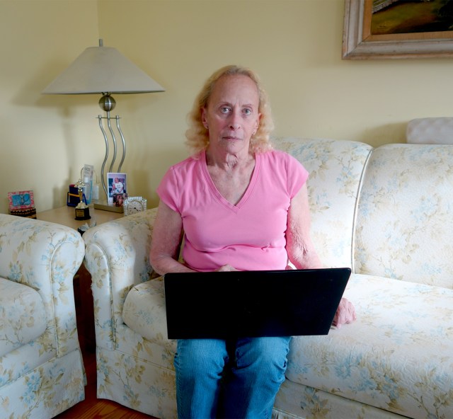 Judy, 79, sits with a laptop.