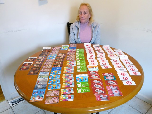 Judy sits at her kitchen table with $166,000 in used department store gift cards.