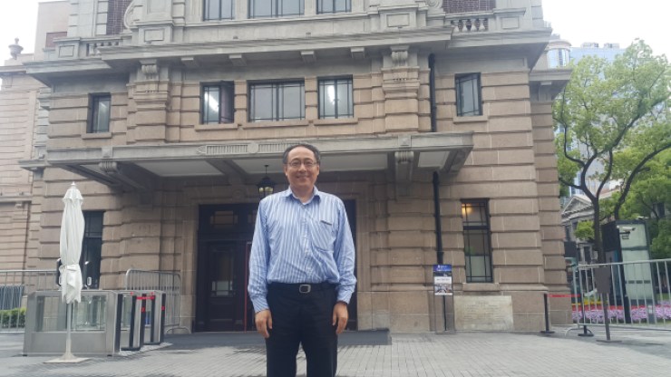 Charles Liu poses in front of the Shanghai History Museum. The site formerly housed a library, which he credits for helping him enter university and altering the course of his life. Credit: Jennifer Pak/Marketplace
