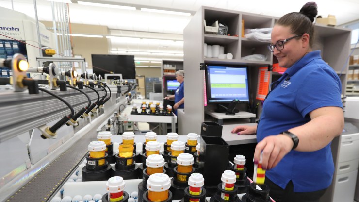 A pharmacy technician prepares prescriptions for packaging and shipping after being filled on an automated line at the central pharmacy of Intermountain Heathcare in 2018 in Midvale, Utah.
