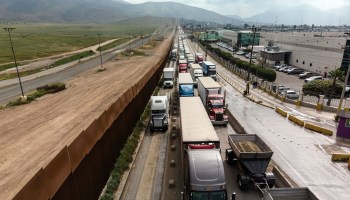 Aerial view of cargo trucks lining up to cross to the United States near the US-Mexico border at Otay Mesa crossing port in Tijuana, Baja California state, Mexico, on April 4, 2019.