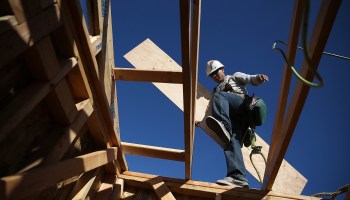 A construction worker carries lumber as he builds a new home in Petaluma, California, in 2015.