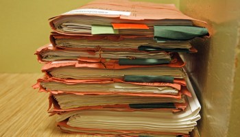 A stack of paperwork in folders.