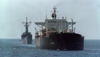 An oil tanker is protected by the U.S. guided missile frigate USS Gallery in the Strait of Hormuz in 1988. In a tweet Monday, President Donald Trump questioned the United States' decadeslong protection of the strait.