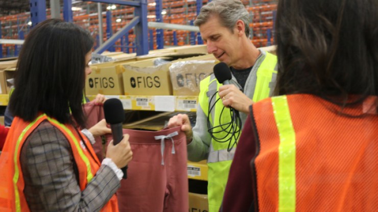 FIGS Co-CEO/Co-Founder Trina Spear shows Marketplace's Kai Ryssdal a set of FIGS scrubs.