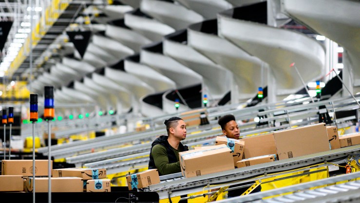 Men work at a distribution station in the 855,000-square-foot Amazon fulfillment center in Staten Island, New York.