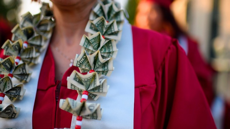 A graduating student wears a money lei, a necklace made of US dollar bills, at the Pasadena City College graduation ceremony, June 14, 2019, in Pasadena, California.
