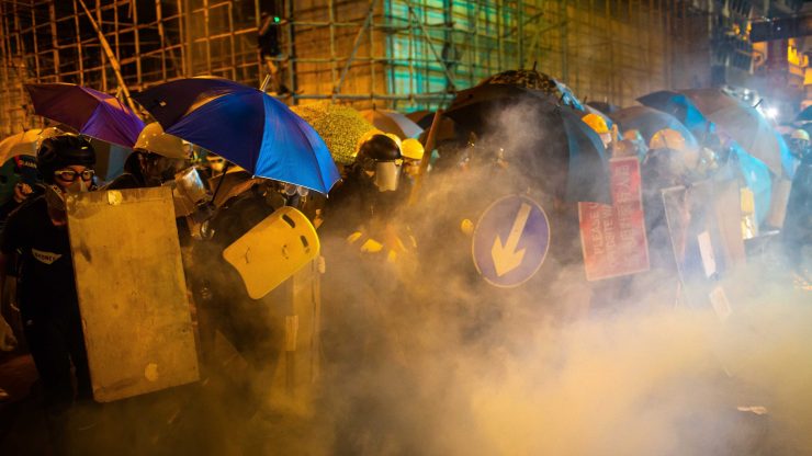 Protesters are enveloped by tear gas on a street during a demonstration in the area of Sheung Wan on July 28 in Hong Kong.