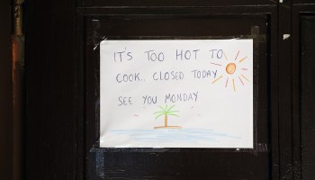 A sign in a Berlin restaurant window on June 30 reads "It's too hot to cook. Closed today. See you Monday."