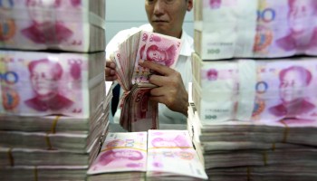 A Chinese bank clerk counts banknotes