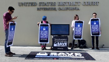 Protesters hold placards reading "Secure Phones Saves Lives" in front of the U.S. District Court in Riverside, California, where a hearing was set for legal arguments to force Apple to provide technical assistance to hack into an encrypted handset in 2016.