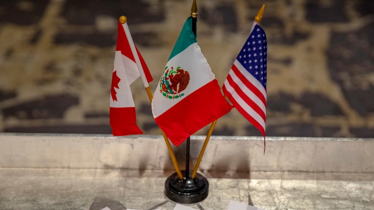 The Canadian, Mexican and American flags together in a stand.