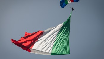 A paratrooper holding an Italian flag