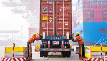 Workers prepare a container at the port in Qingdao, China's eastern Shandong province, in earlier this year.