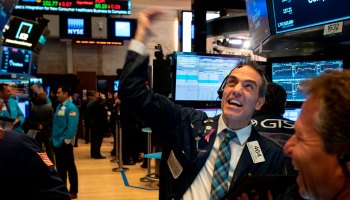 A trader at the New York Stock Exchange waves his arm and yells.