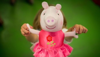 A boy holds a "Once Upon a Time Princess Rose" Peppa Pig toy at Hamleys in London in 2015.