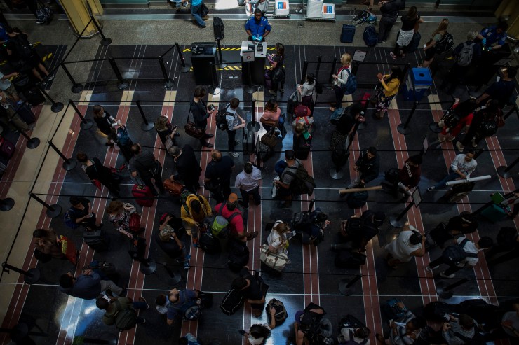 Travelers wait in line to go through a security checkpoint at Reagan National Airport in Arlington, Virginia, in May.