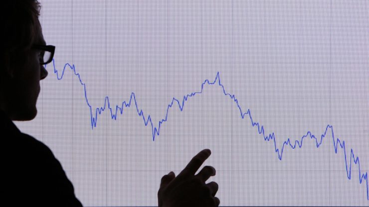 A man looks at a graph representing the 12 month decline on October 7, 2008 in London.