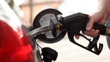 A gasoline pump nozzle in a car gas tank.