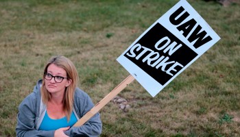 Jennifer Odum, a United Auto Workers member who is employed at the General Motors Flint Assembly plant in Michigan, sits on the curb as she strikes on Sept. 16.