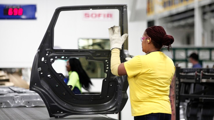 A worker handles a car door at a Chrysler plant in Warren, Michigan, in 2016.