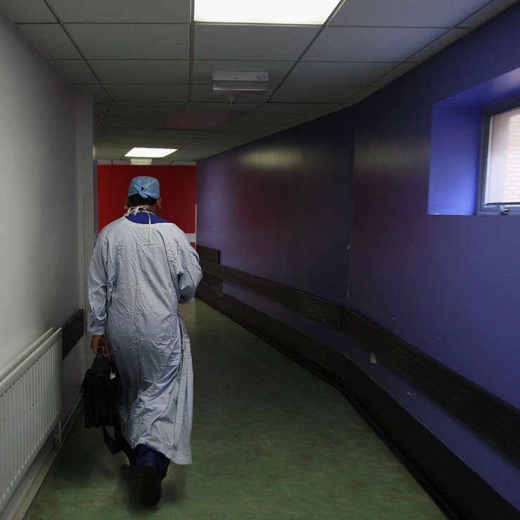 A surgeon walks down a hospital hallway
