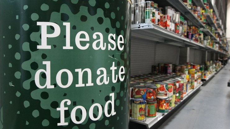 A donation bin sits near shelves with canned foods at the San Francisco Food Bank.