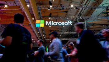 Attendees walk past the Microsoft logo during the Web Summit in Lisbon, Portugal, on Nov. 6.