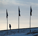 A woman under tribal flags at the Standing Rock Sioux Reservation in 2016.