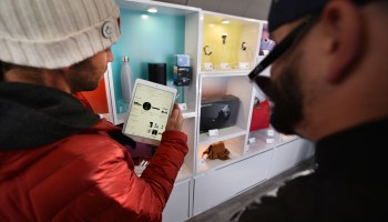 An eBay representative shows customers the eBay app at a holiday market in Denver in 2017.