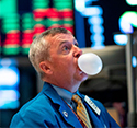 A trader blows a bubble from gum on the floor of the NYSE