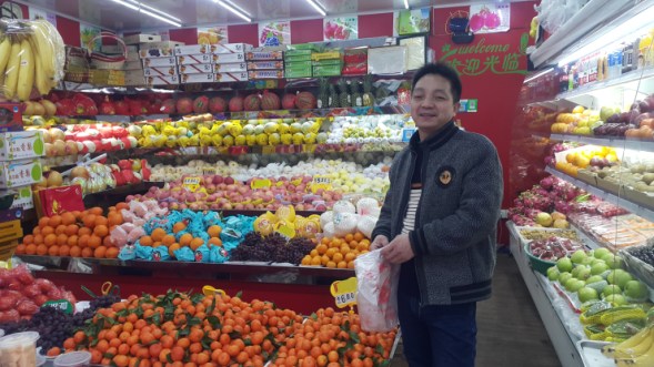 Qiu Jianxian keeps his fruit stall open during the Lunar New Year but this year he expects business to be bad because there is not enough foot traffic on his street. (Credit: Jennifer Pak/Marketplace)