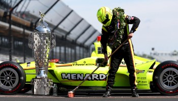 Simon Pagenaud of France, driver of the #22 Team Penske Chevrolet, sweeps the bricks during the winner's portrait session after the 103rd Indianapolis 500 in 2019 in Indianapolis, Indiana.