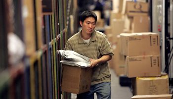 A UPS worker sorts packages to be loaded onto a delivery truck at the UPS sort facility in South San Francisco, California.