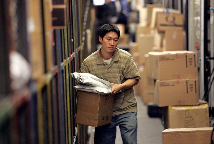 A UPS worker sorts packages to be loaded onto a delivery truck at the UPS sort facility in South San Francisco, California.