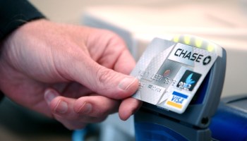 A person scans their Chase credit card at a register.