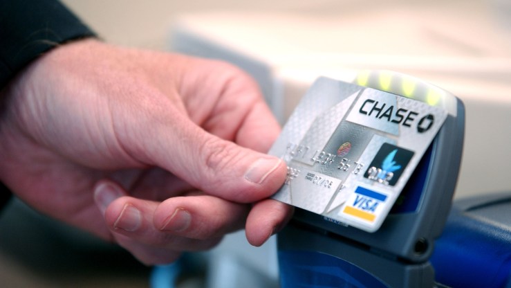 A person scans their Chase credit card at a register.