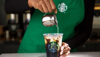 A barista pours cream into a cup of Starbucks' cold brew coffee