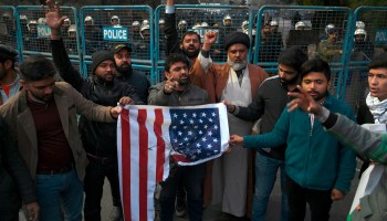 Protesters in Lahore, Pakistan, hold a burned U.S. flag on Friday as they shout slogans during a demonstration near the U.S. consulate following a U.S. airstrike that killed Iranian commander Qassem Soleimani in Iraq.